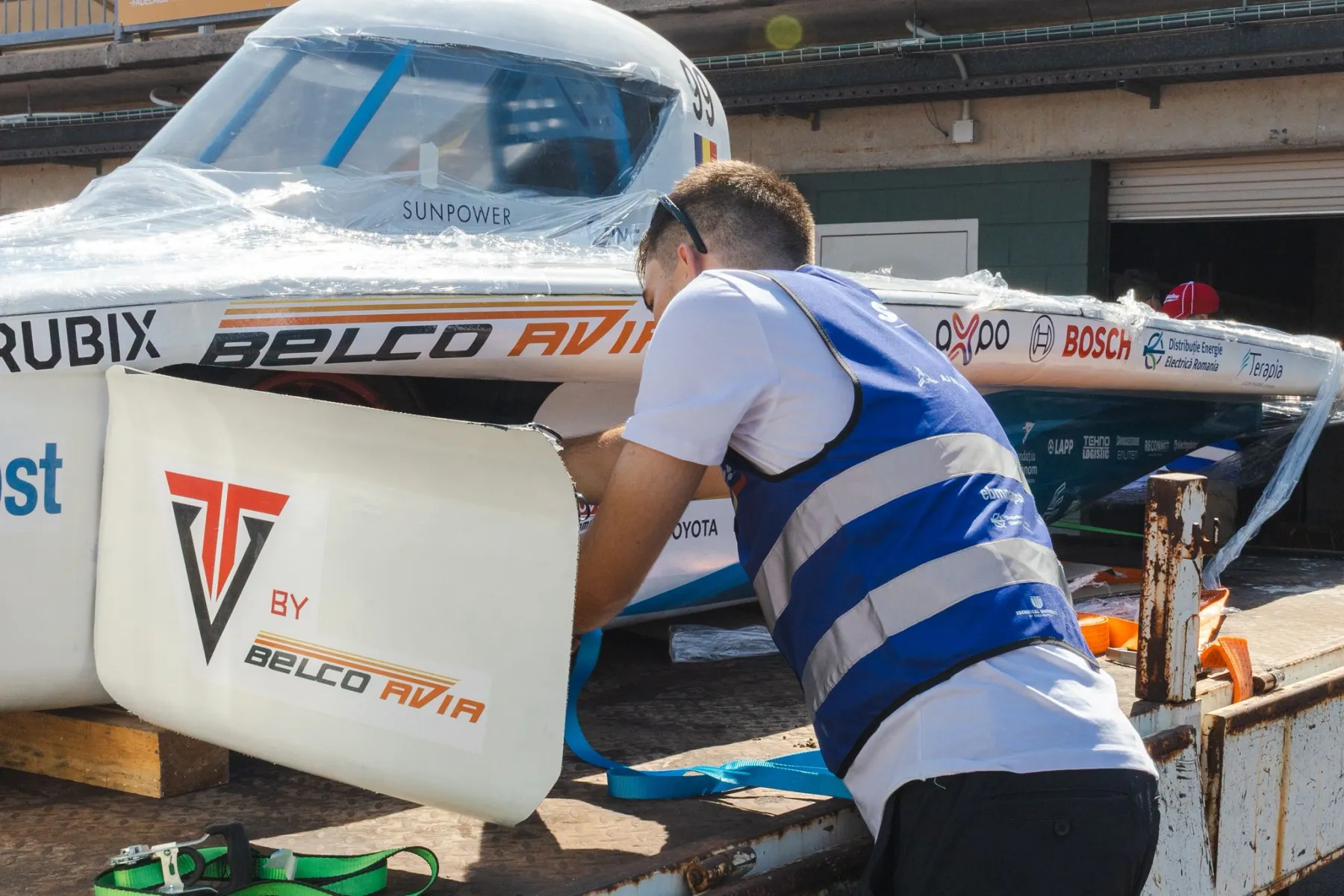 Strapping the Solis solar car down in the pit lane before the race